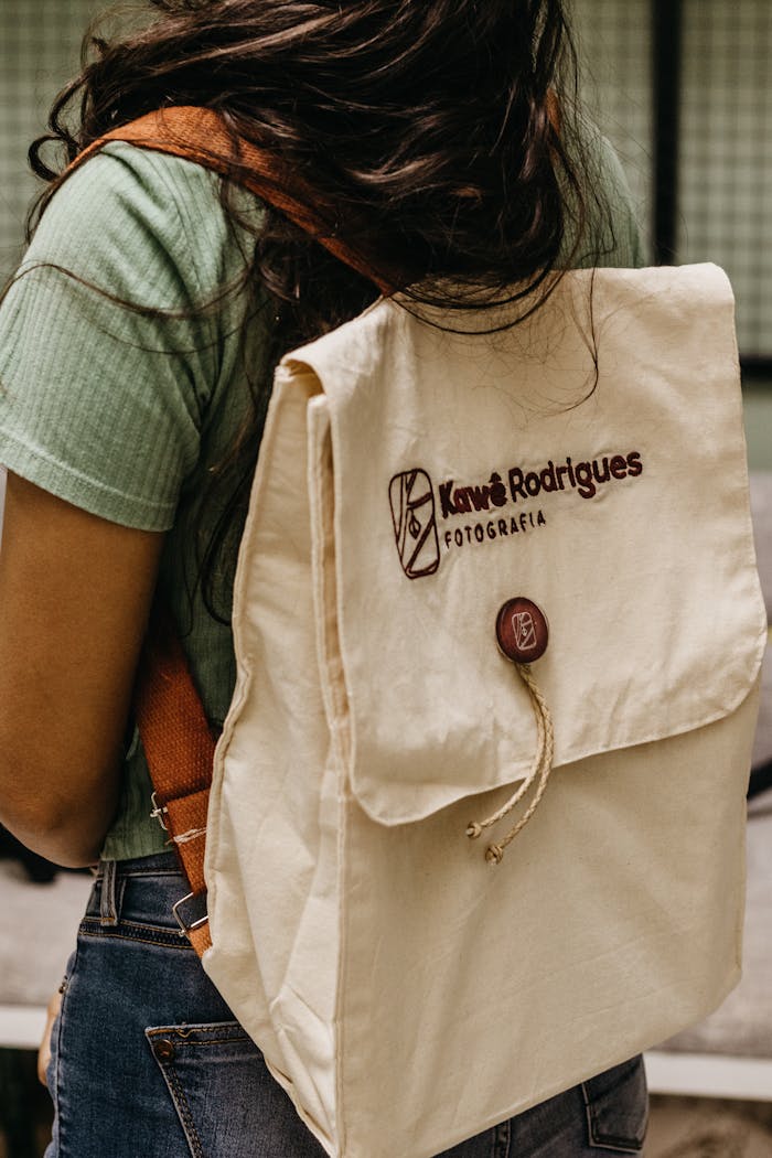 about-us-02 A linen backpack with a custom logo worn by a woman in casual street fashion.